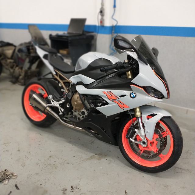 Moto esportiva branca com rodas laranja